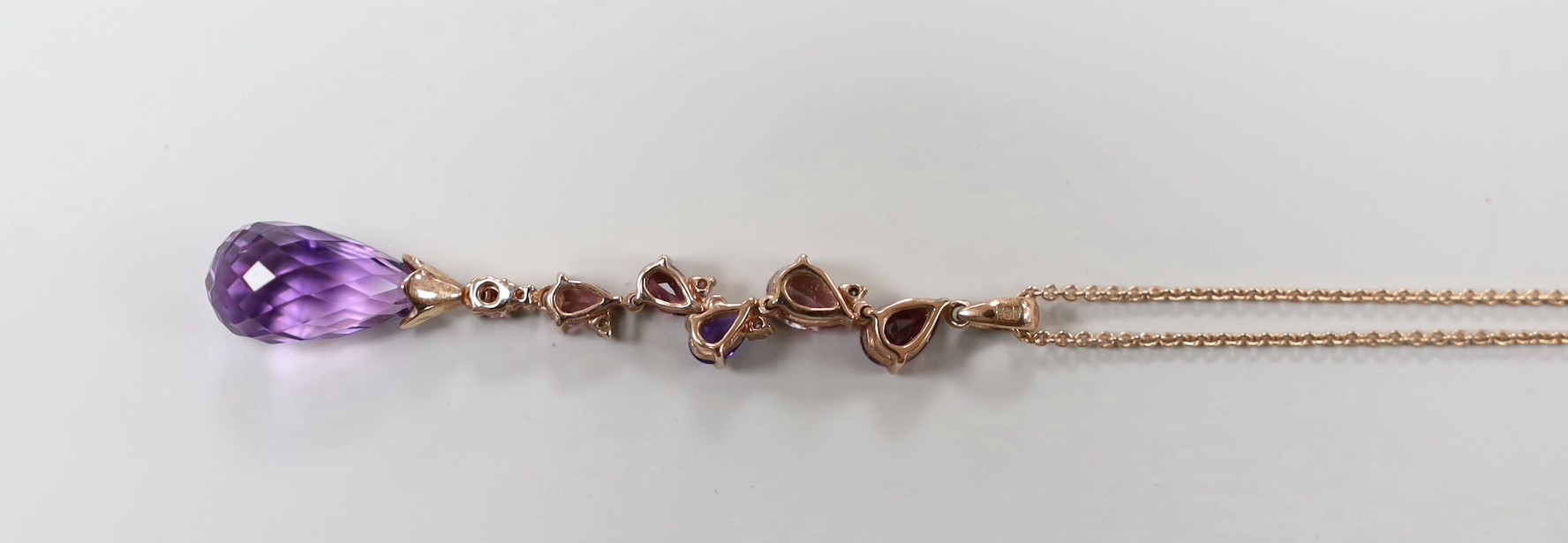 A modern 9ct gold, garnet, topaz, amethyst and diamond chip set drop pendant necklace, pendant 46mm, chain 46cm, gross weight 4.7 grams.